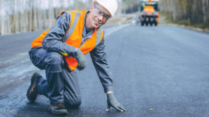 construction worker kneeling on road